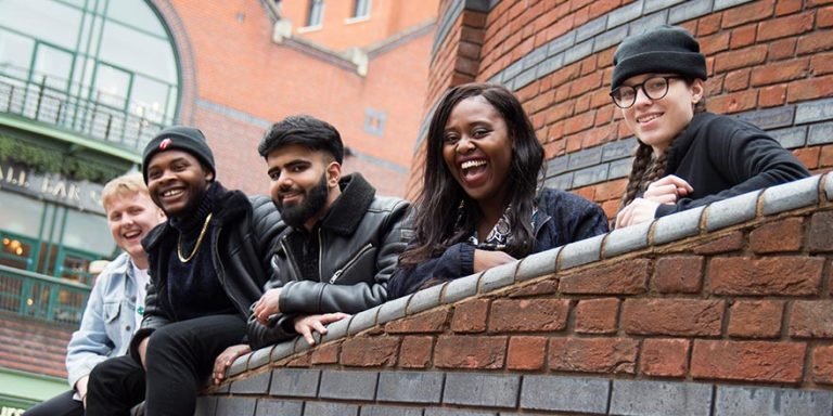 Picture of 5 representatives from beatfreeks leaning on a wall smiling